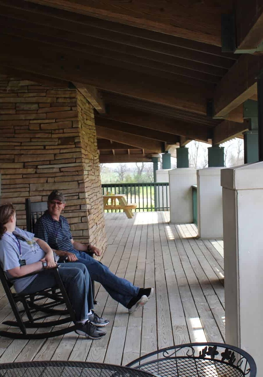 Two chairs on a dock overlooking a pond